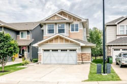 Two-story home with a two-car garage, stone accents, and a gabled roofline - 