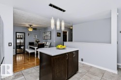 Kitchen island with white countertop and dark wood-finish cabinetry - 