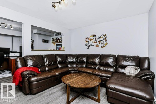 Wood-finish flooring throughout, a pass-through window with a built-in shelf, and track lighting fixtures - 18431 95A Avenue Nw, Edmonton, AB 