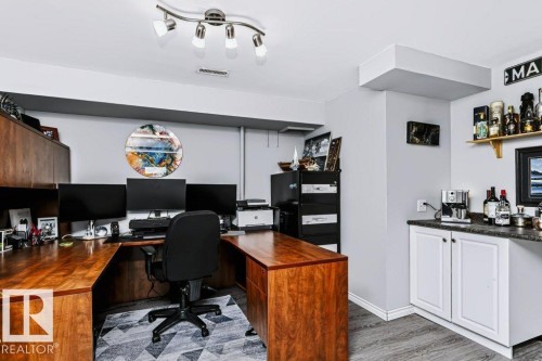 Dedicated office space featuring built-in wood cabinetry and a track lighting fixture - 18431 95A Avenue Nw, Edmonton, AB 