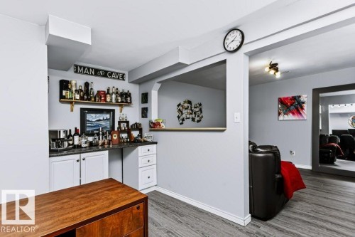 Built-in wet bar with white cabinetry and dark countertops - 18431 95A Avenue Nw, Edmonton, AB 