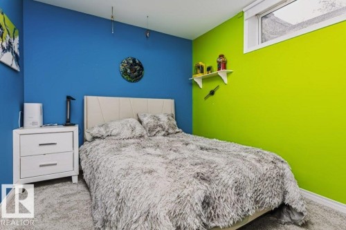 Carpeted room with a horizontal window, featuring a padded headboard and a two-drawer nightstand - 18431 95A Avenue Nw, Edmonton, AB 