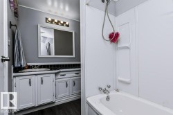 White vanity with dark hardware, a single basin sink, and a framed mirror - 