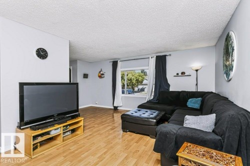 Expansive interior with wood-finish flooring and a large window - 18431 95A Avenue Nw, Edmonton, AB 