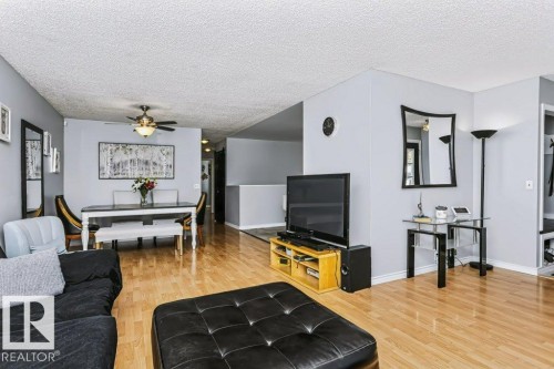 Light wood-finish flooring throughout, light gray wall tones, ceiling fan with integrated lighting, and a built-in entry nook with shelving - 18431 95A Avenue Nw, Edmonton, AB 