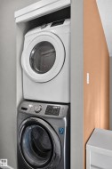 Stacked washer and dryer units within a dedicated alcove - 