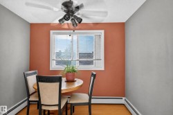 Window with blinds, ceiling fan with light fixture, hardwood flooring, baseboard heating, and a painted accent wall - 