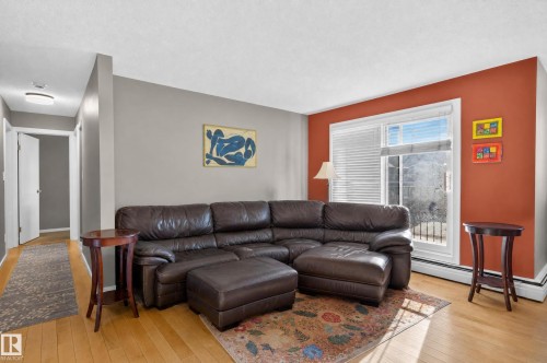 Light wood-finish flooring complements the interior wall colors - #204 7407 171 St Nw, Edmonton, AB 
