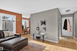 Hardwood-style flooring throughout, ceiling fan, multiple windows with blinds, and a built-in entry console - 