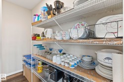Pantry featuring white wire shelving, light neutral wall paint, and wood-finish flooring - 