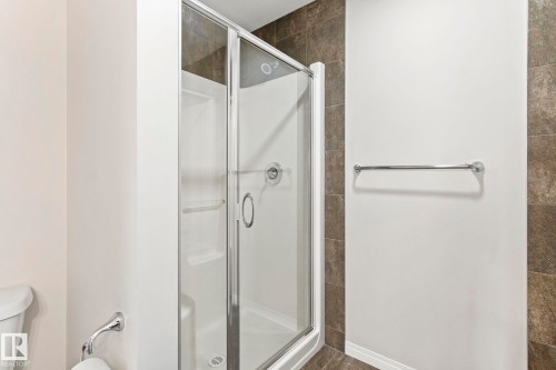 Glass-enclosed shower stall with a white base and silver-toned hardware - 2131 51 Sw, Edmonton, AB - Indoor Photo Showing Bathroom