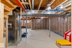 Unfinished basement with exposed ceiling joists, substantial ductwork, and framed, insulated walls - 
