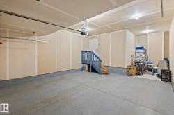Spacious garage featuring a durable epoxy floor coating, interior access door, and a built-in staircase - 