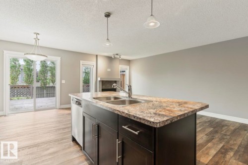 Kitchen island featuring a double-basin sink and integrated dishwasher - 79 Catalina Crest, Fort Saskatchewan, AB - Indoor Photo Showing Kitchen With Double Sink