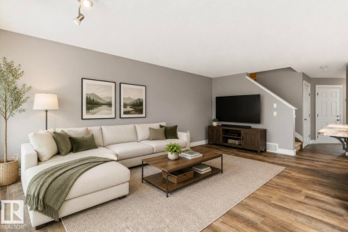 Spacious living area featuring light gray walls, track lighting, and wood-finish flooring - 79 Catalina Crest, Fort Saskatchewan, AB - Indoor Photo Showing Living Room