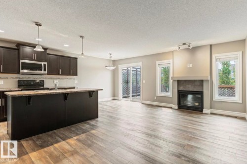 Open-concept living area featuring wood-finish flooring - 79 Catalina Crest, Fort Saskatchewan, AB - Indoor With Fireplace
