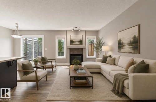 Spacious living area featuring wood-finish flooring, a contemporary fireplace with a stone surround, and an integrated wet bar with a stone countertop - 79 Catalina Crest, Fort Saskatchewan, AB - Indoor Photo Showing Living Room With Fireplace