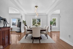 Hardwood flooring throughout, archways, and a tray ceiling - 