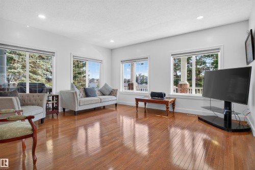 Hardwood flooring, recessed lighting, white walls, and multiple large windows with trim - 1251 Summerside Drive Sw, Edmonton, AB 