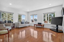 Hardwood flooring, recessed lighting, white walls, and multiple large windows with trim - 