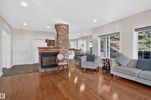 Hardwood flooring, brick fireplace with wood mantel, recessed lighting, double-pane windows, and a tiled entryway - 1251 Summerside Drive Sw, Edmonton, AB 