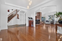 Hardwood flooring extends throughout, complemented by arched entryways - 