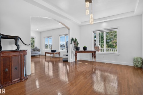 Hardwood flooring, recessed lighting, arched entryway, tray ceiling, and multiple windows - 1251 Summerside Drive Sw, Edmonton, AB 