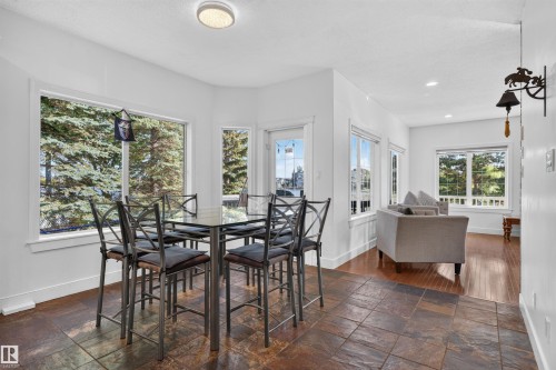 Recessed ceiling lighting, white trim, expansive windows, tiled flooring, and wood-finish flooring - 1251 Summerside Drive Sw, Edmonton, AB 