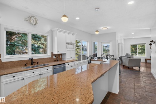 Kitchen featuring white cabinetry, a double basin sink with a black faucet, and light brown speckled countertops - 1251 Summerside Drive Sw, Edmonton, AB 