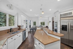 Kitchen featuring white cabinetry, stone countertops, stainless steel appliances, and tile flooring - 
