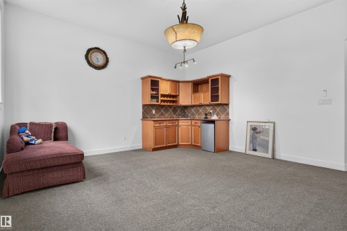 Built-in corner cabinetry with integrated wine storage, under-cabinet lighting, and a beverage refrigerator - 1251 Summerside Drive Sw, Edmonton, AB 
