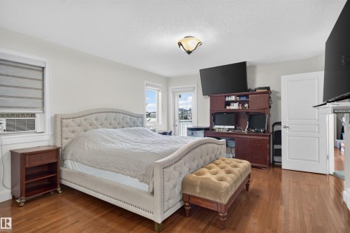 Hardwood flooring, light wall finishes, built-in desk cabinetry, and a ceiling-mounted light fixture - 1251 Summerside Drive Sw, Edmonton, AB 