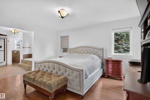 Hardwood flooring, white walls, recessed window, ceiling-mounted light fixtures, and a tiled bathroom area with a built-in tub - 1251 Summerside Drive Sw, Edmonton, AB 