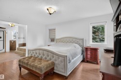 Hardwood flooring, white walls, recessed window, ceiling-mounted light fixtures, and a tiled bathroom area with a built-in tub - 