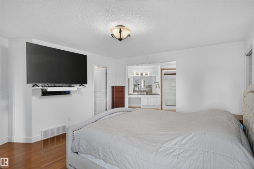 Wood-finish flooring with white walls and a built-in entertainment niche - 1251 Summerside Drive Sw, Edmonton, AB 