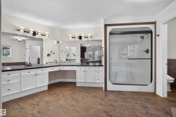 Dual vanity with dark countertops and white cabinetry - 
