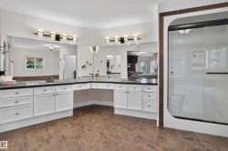 Dual vanity with white cabinetry, dark countertops, and integrated sinks - 