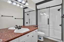 Dual vanity with white cabinetry and a red granite-style countertop - 