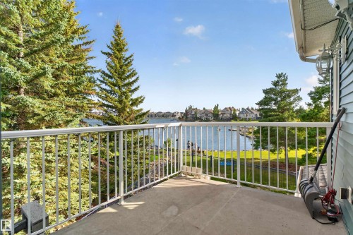 Concrete balcony with white metal railing, offering a waterfront orientation - 1251 Summerside Drive Sw, Edmonton, AB 