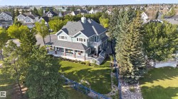 Two-story residence with a covered porch, multiple balconies, and a stone patio - 