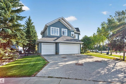 Two-story home with blue siding, a two-car garage, and a concrete driveway - 1251 Summerside Drive Sw, Edmonton, AB 