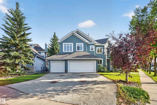 Two-story residence with blue siding, a two-car garage, and a textured driveway - 1251 Summerside Drive Sw, Edmonton, AB 