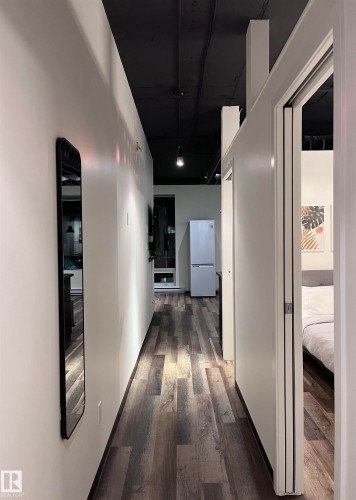 Hallway with wood-finish flooring, white walls, and a black ceiling - #1701 10024 Jasper Av Nw, Edmonton, AB 