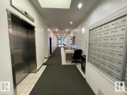 Central hallway with tile flooring, recessed lighting, and a bank of mailboxes - 