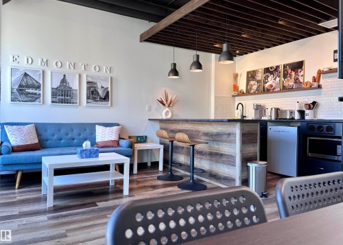 Wood-finish flooring, exposed wood beam ceiling, recessed lighting, integrated kitchen appliances, and subway tile backsplash - #1701 10024 Jasper Av Nw, Edmonton, AB 