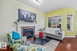 Warm living space featuring wood-finish flooring, a fireplace with a mantel, and multiple windows with blinds - 