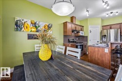 Wood-finish flooring, recessed lighting, wood cabinetry, stainless steel appliances, and a kitchen island with a sink - 