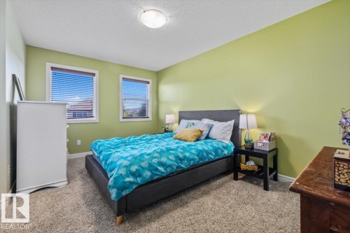 Carpeted flooring, two windows with blinds, and a flush-mount ceiling light - 11506 17 Avenue Sw, Edmonton, AB 