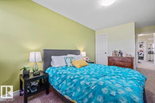 Textured carpet flooring, interior door with dark hardware, recessed ceiling light, and light-toned walls - 11506 17 Avenue Sw, Edmonton, AB 