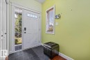 Entryway with a white paneled door featuring a transom window, sidelight, and matte black hardware - 11506 17 Avenue Sw, Edmonton, AB 